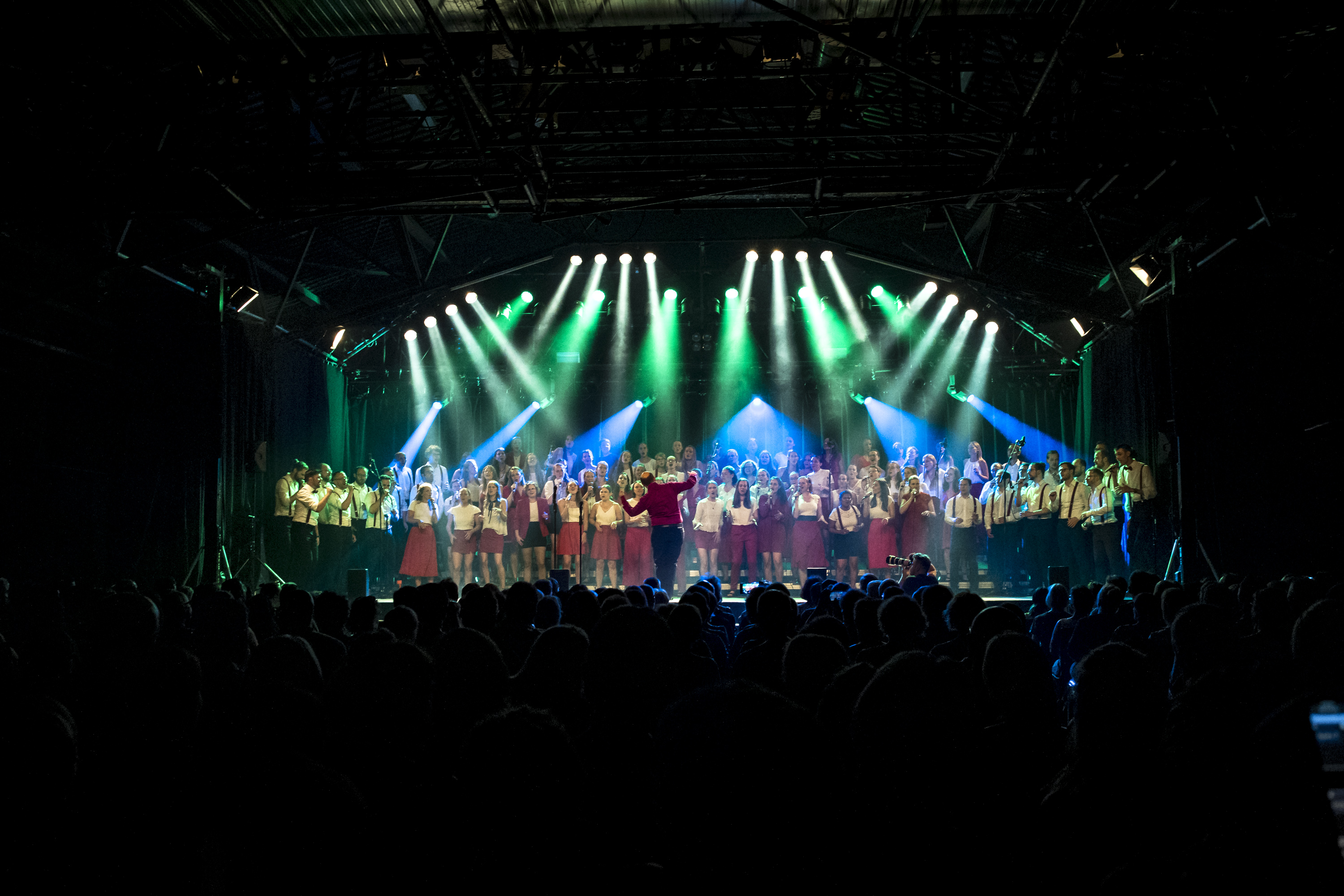 Jubiläumskonzerte im Roxy Der Chor steht auf der Bühne des Roxy und wird effektvoll beleuchtet